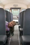 Komt de IThe jonge Kaukasische blonde meisjes uit uit de bus` s zetel Zij zit in een school-bus stock foto Komt de IThe jonge Kaukasische blonde meisjes uit uit de bus` s zetel Zij zit in een school-bus stock foto