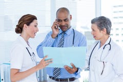 Koncentrerad doktorsvisningmapp till hans kollegor, medan kalla royaltyfri bild Koncentrerad doktorsvisningmapp till hans kollegor, medan kalla royaltyfri bild