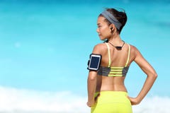Konditionlöparekvinna med passformen som bär tillbaka telefonarmbindel- och radiohörlurar royaltyfri bild Konditionlöparekvinna med passformen som bär tillbaka telefonarmbindel- och radiohörlurar royaltyfri bild