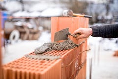 Konstruktionsplats med väggar för arbetarbyggnadstegelsten med mortel och tegelstenar royaltyfria bilder Konstruktionsplats med väggar för arbetarbyggnadstegelsten med mortel och tegelstenar royaltyfria bilder