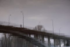 Konturperson på bron med gatalyktor arkivfoto Konturperson på bron med gatalyktor arkivfoto