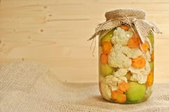 Konzept des Saisonessiggurkenglases an bedeckt mit dem Sackleinen voll von farbigen grünen rohen Tomaten, von der orange Karotte stockfotografie Konzept des Saisonessiggurkenglases an bedeckt mit dem Sackleinen voll von farbigen grünen rohen Tomaten, von der orange Karotte stockfotografie