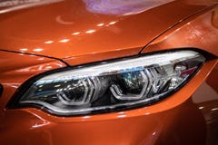 Koplamp van oranje moderne auto met LEIDEN licht stock foto's Koplamp van oranje moderne auto met LEIDEN licht stock foto's