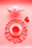 Kopp av parfymerat rosa te på att virka servetten, tekannan och kuvertet på fönsterbräda red steg Romansk bra morgon som bor royaltyfri fotografi Kopp av parfymerat rosa te på att virka servetten, tekannan och kuvertet på fönsterbräda red steg Romansk bra morgon som bor royaltyfri fotografi