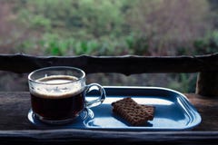 Kopp av thailändskt kaffe med kakor på trätabellen i ett bergkafé Royaltyfri Fotografi Kopp av thailändskt kaffe med kakor på trätabellen i ett bergkafé Royaltyfri Fotografi
