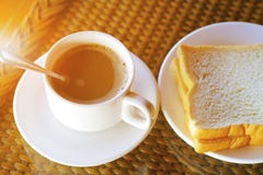 Kopp kaffe och maträtt av bröd på frukosttabellen i morgonen Fotografering för Bildbyråer Kopp kaffe och maträtt av bröd på frukosttabellen i morgonen Fotografering för Bildbyråer