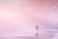 Koppla ihop att gå i stranden på solnedgången arkivbilder Koppla ihop att gå i stranden på solnedgången arkivbilder