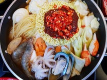 Korean food style, Selective focus of Instant noodles with vegetable, pork sliced, mussel, squid and shrimp in hot pot on wooden stock photography Korean food style, Selective focus of Instant noodles with vegetable, pork sliced, mussel, squid and shrimp in hot pot on wooden stock photography