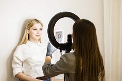 Kosmetiker fotografiert seine Arbeit an einem Handy Zwei Mädchen in einem Schönheitssalon Ringlampe für Maskenbildner Gesichts-So stockbilder Kosmetiker fotografiert seine Arbeit an einem Handy Zwei Mädchen in einem Schönheitssalon Ringlampe für Maskenbildner Gesichts-So stockbilder