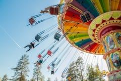 Kouvola, Финляндия - 18-ое мая 2019: Carousel качания езды в движении в парке атракционов Tykkimaki и след воздушных судн в небе стоковые изображения Kouvola, Финляндия - 18-ое мая 2019: Carousel качания езды в движении в парке атракционов Tykkimaki и след воздушных судн в небе стоковые изображения