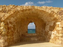 Kraft från en kryphål i en gul tegelstenvägg som avskiljer Chania från havet royaltyfri fotografi Kraft från en kryphål i en gul tegelstenvägg som avskiljer Chania från havet royaltyfri fotografi