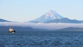 Krai van Rusland, Kamchatka - 31 Augustus, 2018: Het Weergeven van Vilyuchinsky-vulkaan riep ook Vilyuchik van toeristenboot stock afbeelding Krai van Rusland, Kamchatka - 31 Augustus, 2018: Het Weergeven van Vilyuchinsky-vulkaan riep ook Vilyuchik van toeristenboot stock afbeelding