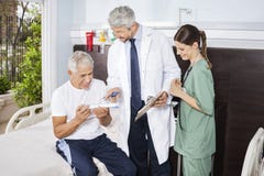 Krankenschwester Looking At Doctor, das Verordnung Patienten erklärt lizenzfreie stockbilder Krankenschwester Looking At Doctor, das Verordnung Patienten erklärt lizenzfreie stockbilder