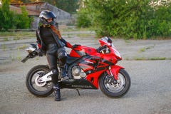KRASNOYARSK, RUSSIA - June 23, 2018: Beautiful girl motorcyclist in full gear and helmet on a red and black Honda 2005 CBR 600 RR Royalty Free Stock Photos KRASNOYARSK, RUSSIA - June 23, 2018: Beautiful girl motorcyclist in full gear and helmet on a red and black Honda 2005 CBR 600 RR Royalty Free Stock Photos