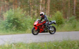 KRASNOYARSK, RUSSIA - June 28, 2018: Beautiful motorcyclist in full gear and helmet on a red and black Honda 2005 CBR 600 RR Royalty Free Stock Photography KRASNOYARSK, RUSSIA - June 28, 2018: Beautiful motorcyclist in full gear and helmet on a red and black Honda 2005 CBR 600 RR Royalty Free Stock Photography