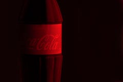 Krasnoïarsk, Russie, le 29 juin 2019 : Classique de Coca-Cola dans une bouteille en verre sur des rouges - fond noir Logo rouge d photos stock Krasnoïarsk, Russie, le 29 juin 2019 : Classique de Coca-Cola dans une bouteille en verre sur des rouges - fond noir Logo rouge d photos stock