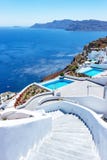 Kroki prowadzi tarasy z wyborowymi pływackimi basenami i uroczystym widokiem głęboki błękitny morze w Oia, Santorini, Grecja fotografia stock Kroki prowadzi tarasy z wyborowymi pływackimi basenami i uroczystym widokiem głęboki błękitny morze w Oia, Santorini, Grecja fotografia stock