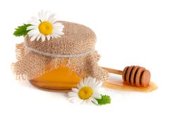 Kruik honing met bloemen van kamille op witte achtergrond wordt geïsoleerd die stock foto Kruik honing met bloemen van kamille op witte achtergrond wordt geïsoleerd die stock foto