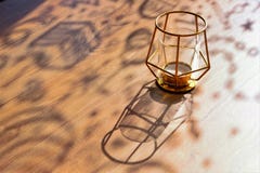 Krullende schaduwen op een houten lijst op een zonnige dag, ontwerperkandelaar, close-up, selectieve nadruk, exemplaarruimte stock afbeeldingen Krullende schaduwen op een houten lijst op een zonnige dag, ontwerperkandelaar, close-up, selectieve nadruk, exemplaarruimte stock afbeeldingen