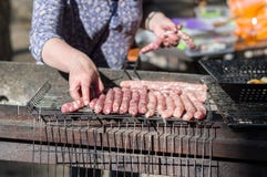 Kulinarne kie?basy na grillu Kie?basy na grillu Dziewczyna przygotowywa kiełbasy na grillu obraz royalty free Kulinarne kie?basy na grillu Kie?basy na grillu Dziewczyna przygotowywa kiełbasy na grillu obraz royalty free