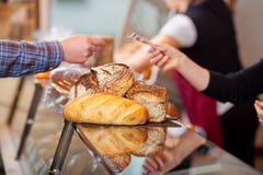 Kunde, der für Brote am Bäckerei-Zähler zahlt lizenzfreies stockbild Kunde, der für Brote am Bäckerei-Zähler zahlt lizenzfreies stockbild