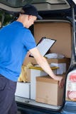 Kurier und ein Auto voll von Paketen lizenzfreies stockbild Kurier und ein Auto voll von Paketen lizenzfreies stockbild