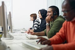 Kursteilnehmer mit Kopfhörer im Computerlabor lizenzfreie stockfotos Kursteilnehmer mit Kopfhörer im Computerlabor lizenzfreie stockfotos