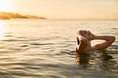 kvinna för vatten för brunnsort för hälsa för huvuddelomsorgsfot Kvinna som tycker om havet, solnedgång Sund livsstil Sommar arkivfoton kvinna för vatten för brunnsort för hälsa för huvuddelomsorgsfot Kvinna som tycker om havet, solnedgång Sund livsstil Sommar arkivfoton