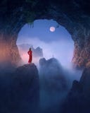 Kvinna i r?d kl?nning mot m?nen i sp?klik grotta royaltyfria foton Kvinna i r?d kl?nning mot m?nen i sp?klik grotta royaltyfria foton