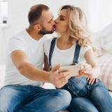 Kvinna och hennes make i jeans som tar självståenden royaltyfri bild Kvinna och hennes make i jeans som tar självståenden royaltyfri bild
