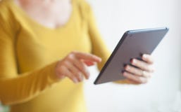 Kvinna som använder en digital minnestavla arkivfoto Kvinna som använder en digital minnestavla arkivfoto
