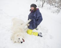 Kvinna som spelar med en vit hund i snön fotografering för bildbyråer Kvinna som spelar med en vit hund i snön fotografering för bildbyråer