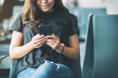 Kvinnahandelsresande som anv?nder mobiltelefonen, medan sitta i flygplatsen royaltyfria foton Kvinnahandelsresande som anv?nder mobiltelefonen, medan sitta i flygplatsen royaltyfria foton
