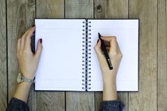 Kvinnahandhandstil på anteckningsboken med pennan royaltyfri fotografi Kvinnahandhandstil på anteckningsboken med pennan royaltyfri fotografi