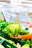 Kvinnaköpandegrönsaker i supermarket Fotografering för Bildbyråer Kvinnaköpandegrönsaker i supermarket Fotografering för Bildbyråer