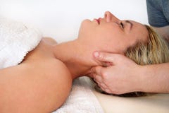 Kvinnan som tar en massagehals, tränga sig in på massagetabellen royaltyfri fotografi Kvinnan som tar en massagehals, tränga sig in på massagetabellen royaltyfri fotografi
