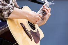 Kvinnas händer som spelar closeupen för akustisk gitarr arkivfoto Kvinnas händer som spelar closeupen för akustisk gitarr arkivfoto