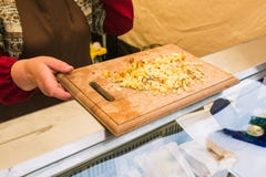 Kvinnasäljaren för att smaka ost En bondeproducent framlägger och säljer hans ost Skärbräda med ost Ostprodukter arkivbilder Kvinnasäljaren för att smaka ost En bondeproducent framlägger och säljer hans ost Skärbräda med ost Ostprodukter arkivbilder