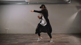 Kvinnlig dansare i den vita skjortan, svart byxa och svarta locket som visar modern jazz-fegis dans i klassrum med speglar arkivfilmer Kvinnlig dansare i den vita skjortan, svart byxa och svarta locket som visar modern jazz-fegis dans i klassrum med speglar arkivfilmer