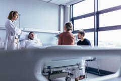 Kvinnlig doktor som besöker patienten i sjukhusrum royaltyfri fotografi Kvinnlig doktor som besöker patienten i sjukhusrum royaltyfri fotografi