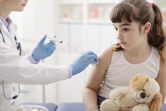 Kvinnlig doktor som ger en injektion till en ung gullig flicka arkivbilder Kvinnlig doktor som ger en injektion till en ung gullig flicka arkivbilder