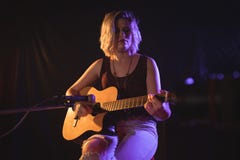 Kvinnlig gitarrist som utför i musikkonsert arkivbilder Kvinnlig gitarrist som utför i musikkonsert arkivbilder
