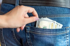 Kvinnlig hand av en ung kvinna som stjäler 100 dollar ut ur fick- manjeans arkivbilder Kvinnlig hand av en ung kvinna som stjäler 100 dollar ut ur fick- manjeans arkivbilder