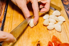 Kvinnlig person som skivar vitlök för att laga mat arkivfoto Kvinnlig person som skivar vitlök för att laga mat arkivfoto