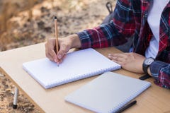 Kvinnlighänder med blyertspennahandstil på anteckningsboken royaltyfri bild Kvinnlighänder med blyertspennahandstil på anteckningsboken royaltyfri bild