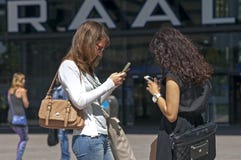 Kvinnor meddelar med smartphonen eller iPhone royaltyfria foton Kvinnor meddelar med smartphonen eller iPhone royaltyfria foton