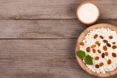 Kwark in kom met zure room en rozijnen op oude houten achtergrond met exemplaarruimte voor uw tekst Hoogste mening Stock Afbeelding Kwark in kom met zure room en rozijnen op oude houten achtergrond met exemplaarruimte voor uw tekst Hoogste mening Stock Afbeelding