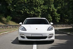 Kyiv, de Oekraïne, 25 Juni, 2015; Wit Porsche Porsche Panamera op de achtergrond van bomen stock afbeeldingen Kyiv, de Oekraïne, 25 Juni, 2015; Wit Porsche Porsche Panamera op de achtergrond van bomen stock afbeeldingen