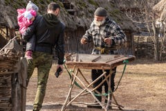 Kyiv UKRAINA - MARS 08, 2019: Mässa av folkkonst i Pirogovo En gråhårig skäggig farfar i gården av ett gammalt traditionellt arkivbild Kyiv UKRAINA - MARS 08, 2019: Mässa av folkkonst i Pirogovo En gråhårig skäggig farfar i gården av ett gammalt traditionellt arkivbild