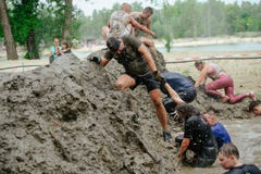 Men and women overcome the water mud barrier during the power race Legion Run, held in Kiev